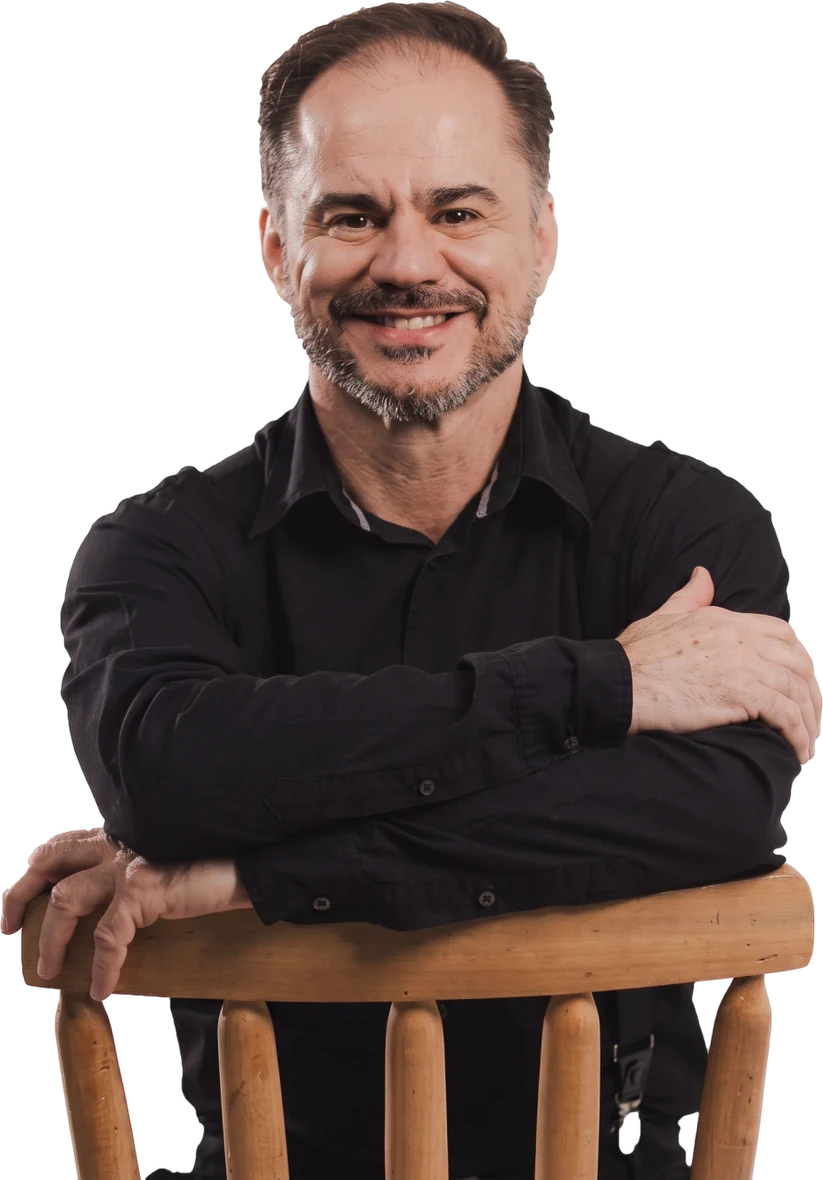 Marcelo Favoretto, psicólogo, sorrindo com os braços apoiados no encosto de uma cadeira